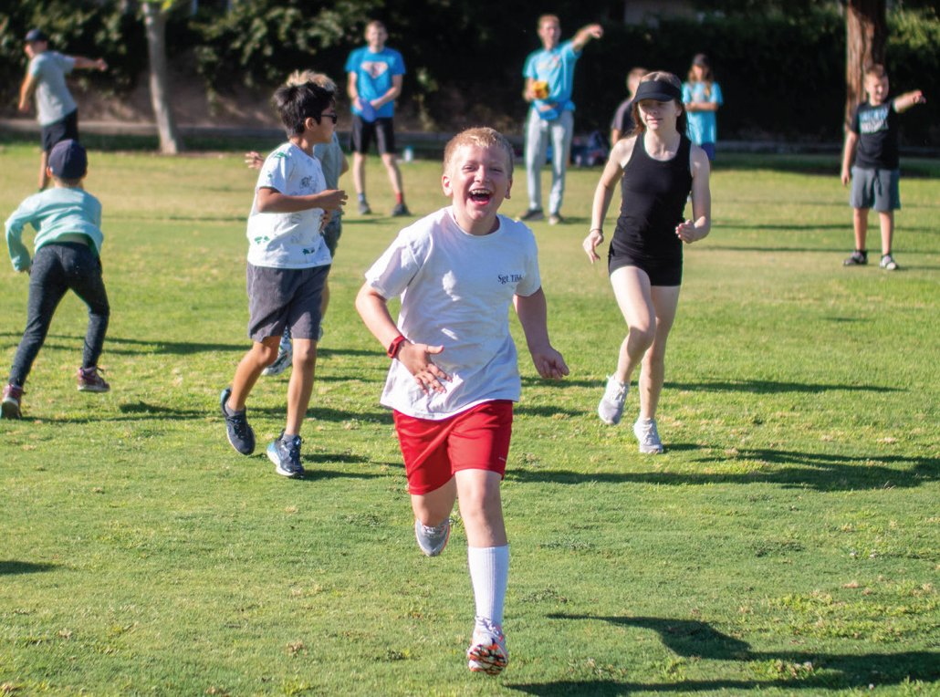 Students running on a soccer field.