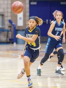 girl chasing basketball during game
